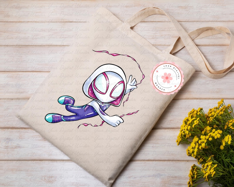 May include: Beige tote bag with a cartoon illustration of a superhero in a white and pink hooded costume, with purple and blue accents. The superhero is in a dynamic pose, with pink web lines. A pink floral sticker is on the bag.