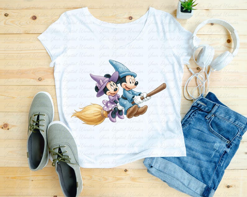 K&ouml;nnte beinhalten: Wei&szlig;es T-Shirt mit einer Cartoon-Illustration von Mickey und Minnie Mouse als Zauberer auf einem Besen. Das Bild zeigt graue Turnschuhe, blaue Jeansshorts und wei&szlig;e Kopfh&ouml;rer. Auf Holz gelegt.