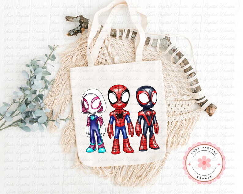 May include: A cream canvas tote bag displaying three cartoon superheroes: Spider-Gwen, Spider-Man, and Miles Morales. The superheroes are in their iconic costumes, with bright colours and strong outlines. The bag rests on a neutral-toned woven surface.