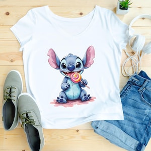 May include: White V-neck t-shirt featuring a watercolor illustration of a blue cartoon character holding a lollipop. The character has large ears and is sitting on a pink surface. The image also includes blue denim shorts, gray sneakers, and white headphones.