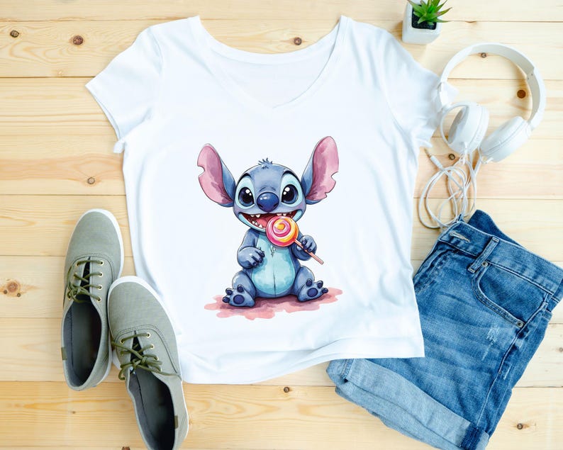 May include: White V-neck t-shirt featuring a watercolor illustration of a blue cartoon character holding a lollipop. The character has large ears and is sitting on a pink surface. The image also includes blue denim shorts, gray sneakers, and white headphones.