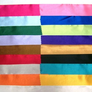 May include: A collection of 14 different colored satin ribbon samples. The ribbons are arranged in rows, with each row featuring a different color. The colors include pink, light blue, dark blue, green, lavender, brown, red, silver, turquoise, orange, and yellow.