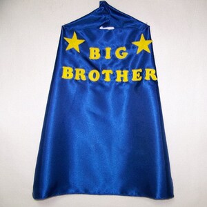 May include: Blue satin cape with yellow felt stars and the words "BIG BROTHER" in yellow felt letters.