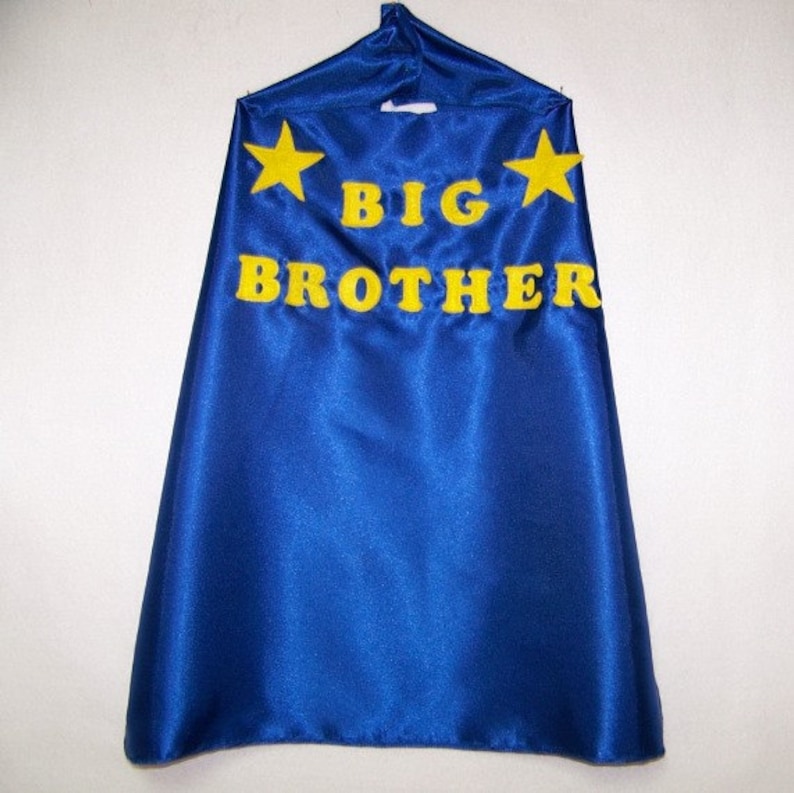 May include: Blue satin cape with yellow felt stars and the words "BIG BROTHER" in yellow felt letters.