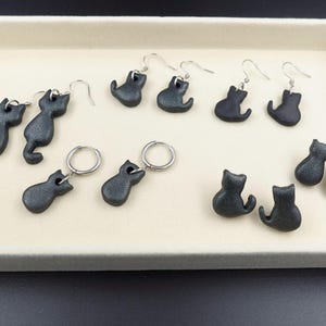 May include: A white ceramic mug with a black handle and the text "But First, Coffee" in a bold, black font. The mug is set against a neutral background, highlighting its simple design.