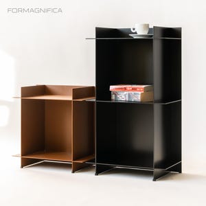 May include: Two contemporary side tables. One is a warm brown, the other is black. The black table has a shelf with two books and a white teacup and saucer. The brand name "FORMAGNIFFICA" is in the top left corner.