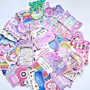 Pode incluir: Uma coleção de autocolantes coloridos em tons de rosa, roxo e azul. Os autocolantes apresentam vários designs, incluindo câmaras, relógios, envelopes e citações inspiradoras. Alguns autocolantes têm texto como "Doing your best" e "Enjoy Every Moment".