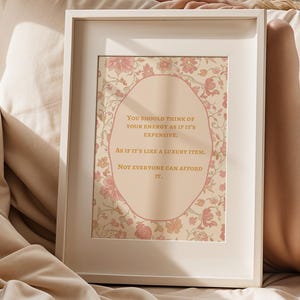 Peut inclure: Une affiche encadrée avec un motif floral et le texte "Vous devriez penser à votre énergie comme si elle était chère. Comme s'il s'agissait d'un article de luxe. Tout le monde ne peut pas se le permettre." Le cadre est blanc.