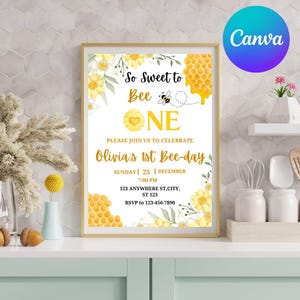 May include: A framed invitation with a bee theme. The text reads "So Sweet to Bee One" with floral and honeycomb accents. The invitation is for Olivia's 1st Bee-day, with date, time, and RSVP information. The Canva logo is in the upper right corner.