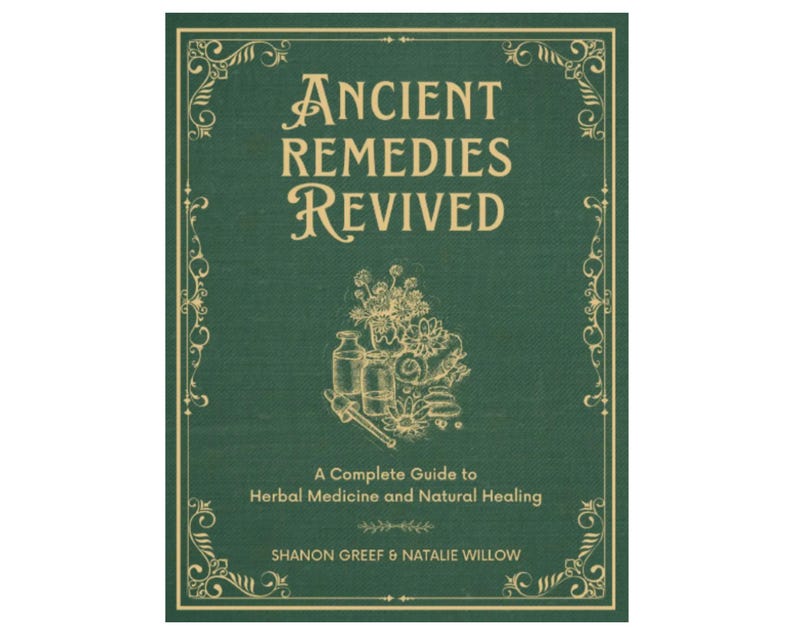 May include: A hardcover book titled "Ancient Remedies Revived" with a green cover and gold decorative border. The book features the text "A Complete Guide to Herbal Medicine and Natural Healing" and the authors' names. An illustration of herbs and bottles is also present.