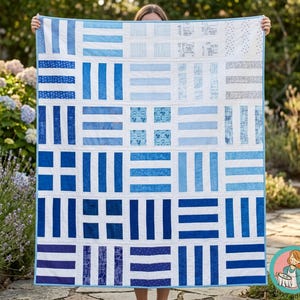 Puede incluir: Un edredón hecho a mano con un patrón geométrico en tonos azules y blancos. El edredón presenta bloques rectangulares y cuadrados, creando un diseño moderno. La paleta de colores incluye varios tonos de azul, de claro a oscuro, sobre un fondo blanco.