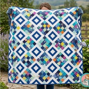 以下が含まれることがあります： 幾何学模様の手作りキルト。キルトは、青い正方形と白いひし形のパターンで、その間にカラフルなパッチワークの正方形があります。キルトは人が持っており、そのサイズとデザインを示しています。