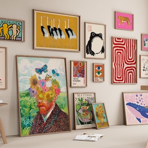 May include: A gallery wall featuring various framed art prints, including a large portrait with a floral head, a red abstract line pattern, a black frog illustration, a yellow crane print, a blue whale, and several other colorful graphic designs.