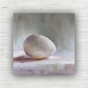 May include: Oil painting of a white egg on a white surface with a soft shadow. The egg is the focal point, with subtle purple and yellow hues. The artist's signature is in the lower left corner. The background is a soft gray.