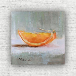 May include: Oil painting of a vibrant orange slice on a white surface, set against a soft, muted green background. The artwork captures the texture and color of the fruit, with visible brushstrokes and a signature in the lower left corner.