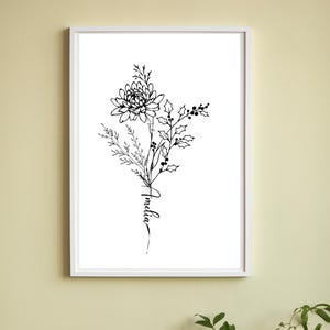 May include: A framed black and white floral art print. The artwork features a detailed illustration of a flower arrangement, including a large bloom, sprigs, and holly. The name "Amelia" is written in cursive script below the flowers.