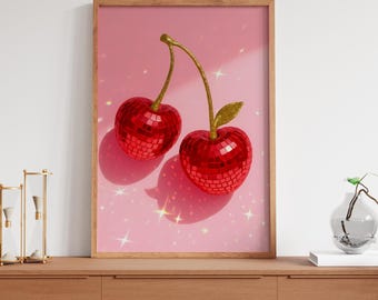 Peut inclure: Deux cerises rouges avec une finition boule disco sur un fond rose avec des paillettes.