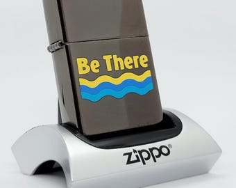 Encendedor Zippo vintage de 2002 con acabado en negro hielo, Newport Be There Advertising: pieza de colección excepcional.