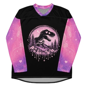 May include: A long-sleeve jersey with a black torso and pink and purple galaxy-patterned sleeves. The front features a circular graphic of a dinosaur silhouette, pine trees, and cherry blossoms against a pink moonlit sky with heart accents.