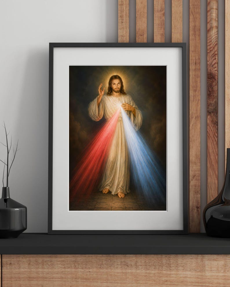 K&ouml;nnte beinhalten: Gerahmtes religi&ouml;ses Kunstwerk, das eine Figur in wei&szlig;en Gew&auml;ndern mit Heiligenschein zeigt, die rotes und blaues Licht ausstrahlt. Das Kunstwerk befindet sich in einem schwarzen Rahmen und wird auf einer Holzoberfl&auml;che ausgestellt.