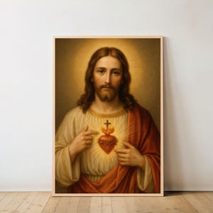 Könnte beinhalten: Gerahmtes Porträt von Jesus Christus, mit langen braunen Haaren und Bart, in einem cremefarbenen Gewand und einem roten Umhang. Er zeigt auf ein flammendes Herz mit einem Kreuz, vor einem goldenen Heiligenschein.