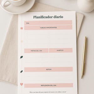 May include: A daily planner with the title "Planificador diario" in Spanish. The planner has sections for tasks, goals, habits, notes, and daily reflection. A cup of coffee, a pen, and a small vase with flowers are also in the image.