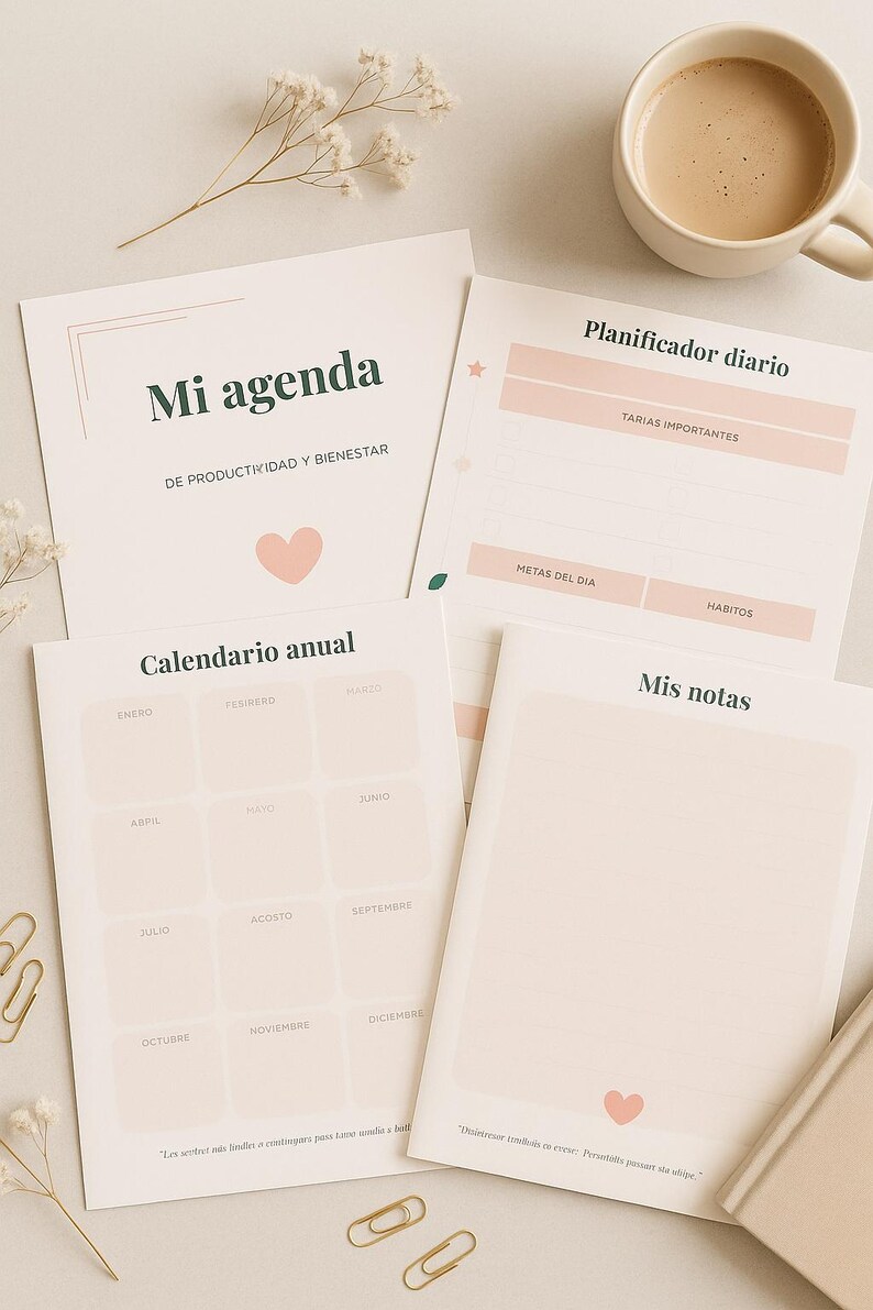 May include: A collection of stationery items, including a daily planner, annual calendar, and notebook. The planner features pink accents and Spanish text. A cup of coffee and decorative sprigs are also present.