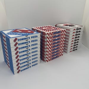 May include: Three stacks of pizza boxes, branded for Domino's Pizza, Antonio's, and Pizza Hut. The Domino's boxes are blue and white with the logo and text. The Antonio's boxes have a red and white checkered pattern. The Pizza Hut boxes are white with red accents.