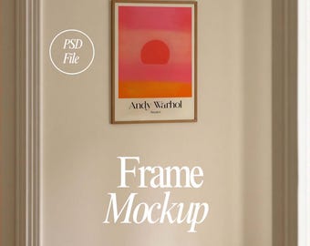 May include: A framed print of a sunset painting by Andy Warhol. The print is in a wooden frame and is hanging on a beige wall. The text "Andy Warhol" and "Sunrise 1" is printed on the bottom of the print.
