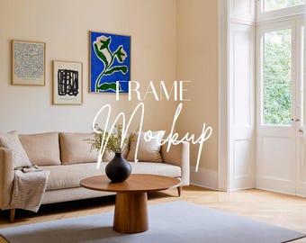 May include: A living room scene with a beige sofa, a round wooden coffee table, and a gray rug. Three framed artworks hang on the wall. A black vase holds greenery. The text "FRAME Mockup" is overlaid on the image.