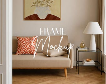 May include: A living room scene with a beige sofa, patterned pillows, and a framed artwork featuring a vase with leaves. A white lamp sits on a black side table. The text "FRAME Mockup" is overlaid on the image.