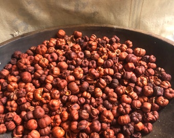 May include: A brown ceramic bowl filled with dried orange peels. The peels are a deep orange color and have a wrinkled texture.