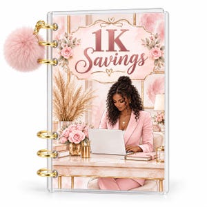 May include: A clear plastic binder featuring a pink pom-pom charm and gold rings. The cover displays an illustration of a person in a pink blazer working on a laptop at a desk, with the text 1K Savings in a decorative frame above the scene.