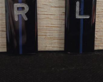 May include: Two black rectangular labels with a blue stripe down the center. The label on the left has the letter "R" printed in white. The label on the right has the letter "L" printed in white.