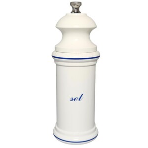 May include: A white ceramic salt grinder with a silver top. The grinder has a cylindrical body with a blue stripe at the top and bottom. The word "sel" is written in blue script on the front.