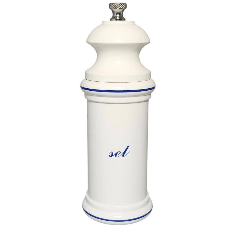 May include: A white ceramic salt grinder with a silver top. The grinder has a cylindrical body with a blue stripe at the top and bottom. The word "sel" is written in blue script on the front.