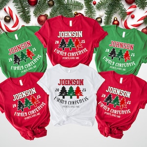 May include: A collection of five short-sleeved t-shirts in red, green, and white. Each shirt features the text JOHNSON, 20 25, FAMILY CHRISTMAS, and PORTLAND, ME, along with a graphic of three stylized Christmas trees in black, green, and red.