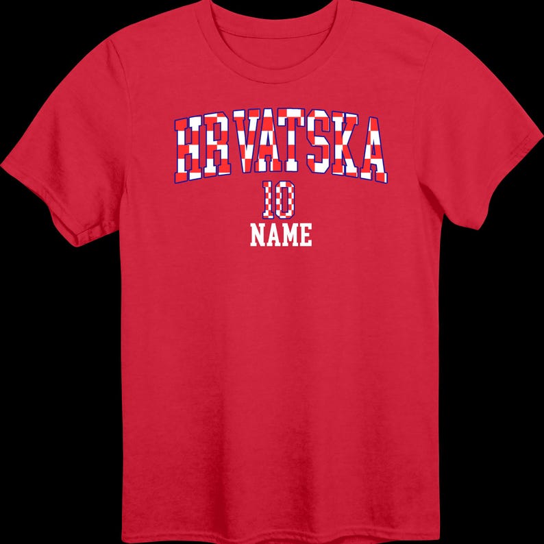 May include: A red short-sleeved t-shirt featuring the text HRVATSKA in a red and white checkered pattern with a blue outline. Below the text is the number 10 in a red and white checkered pattern, followed by the word NAME in white block letters.