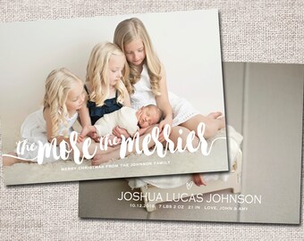 May include: Christmas card featuring a family of four, including a newborn baby. The card has a white background with the text "the more the merrier" in white script. The text "Merry Christmas from the Johnson Family" is also included in white. The card also includes the text "Joshua Lucas Johnson, 10.12.2016, 7 lbs 2 oz, 21 in, Love, John & Amy".