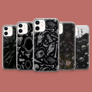 May include: Set of five clear phone cases with different black and white graphic designs. The designs include bones, skulls, flowers, and a shark jaw.