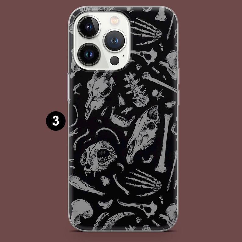 Pode incluir: Uma capa transparente para telefone com fundo preto e um padr&atilde;o branco de v&aacute;rios ossos e cr&acirc;nios.