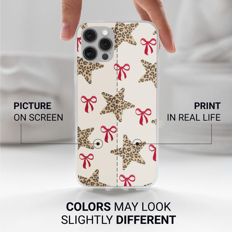 Puede incluir: Una funda transparente para tel&eacute;fono con un patr&oacute;n repetido de estrellas con estampado de leopardo y lazos rojos sobre un fondo crema. El texto "COLORS MAY LOOK SLIGHTLY DIFFERENT" est&aacute; en la parte inferior. La funda del tel&eacute;fono la sostiene una persona.