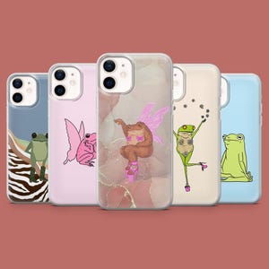 May include: Five different phone cases with frog designs. The cases are clear and show the phone's design underneath. The frogs are in various poses, including a frog with wings, a frog with flowers, and a frog meditating.