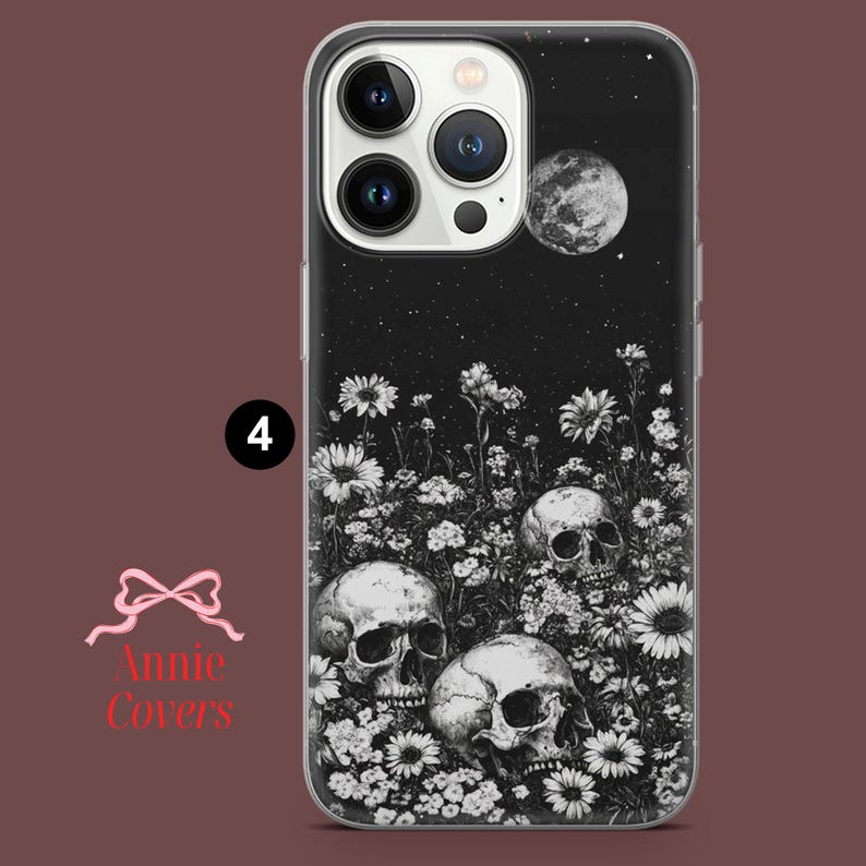 Puede incluir: Carcasa de tel&eacute;fono en blanco y negro con un dise&ntilde;o de tres calaveras rodeadas de flores y una luna creciente. El fondo es una noche estrellada negra.