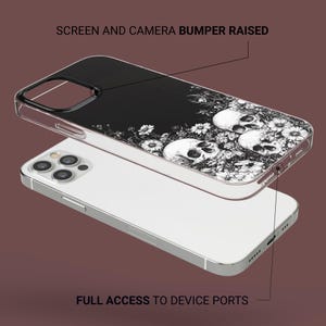 Puede incluir: Una funda transparente para tel&eacute;fono con fondo negro y un dise&ntilde;o de calavera y flores blancas. La funda tiene bordes elevados para proteger la pantalla y la c&aacute;mara. "SCREEN AND CAMERA BUMPER RAISED" y "FULL ACCESS TO DEVICE PORTS" est&aacute;n escritos en la imagen.