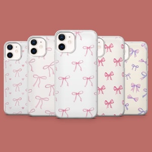May include: Five clear phone cases with a pattern of pink bows. The cases are for an iPhone.