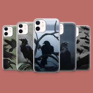 May include: Five phone cases with raven illustrations. The cases show ravens perched on branches, in flight, and as artistic designs. Each case has a clear border. The background is a muted, earthy tone.