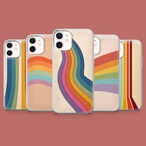 May include: A collection of five phone cases with colorful rainbow designs. The cases feature a variety of rainbow patterns, including curved lines and stripes, set against a cream-colored background. The cases are displayed on a solid red-brown background.
