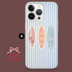 May include: A clear phone case with a blue and white striped background. Three surfboard designs in pink, orange, and blue are featured, each adorned with floral patterns. The number "4" is visible.
