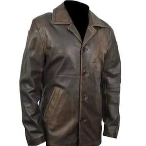 May include: A brown leather jacket with a button-up front, a collared neckline, and a single pocket on the left side. The jacket has a worn, distressed appearance, suggesting a vintage or rugged style. The jacket is displayed against a white background.